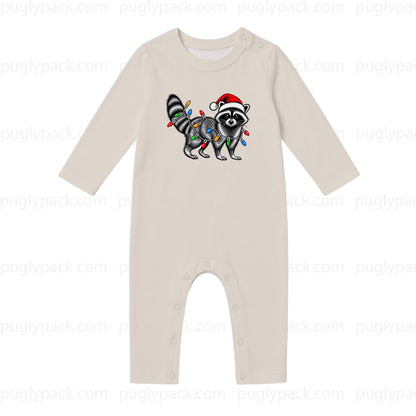 A long-sleeve baby romper in a light oatmeal beige color, featuring a graphic of a raccoon wearing a Santa hat and wrapped in Christmas lights on the chest. The romper has snap closures at the crotch.