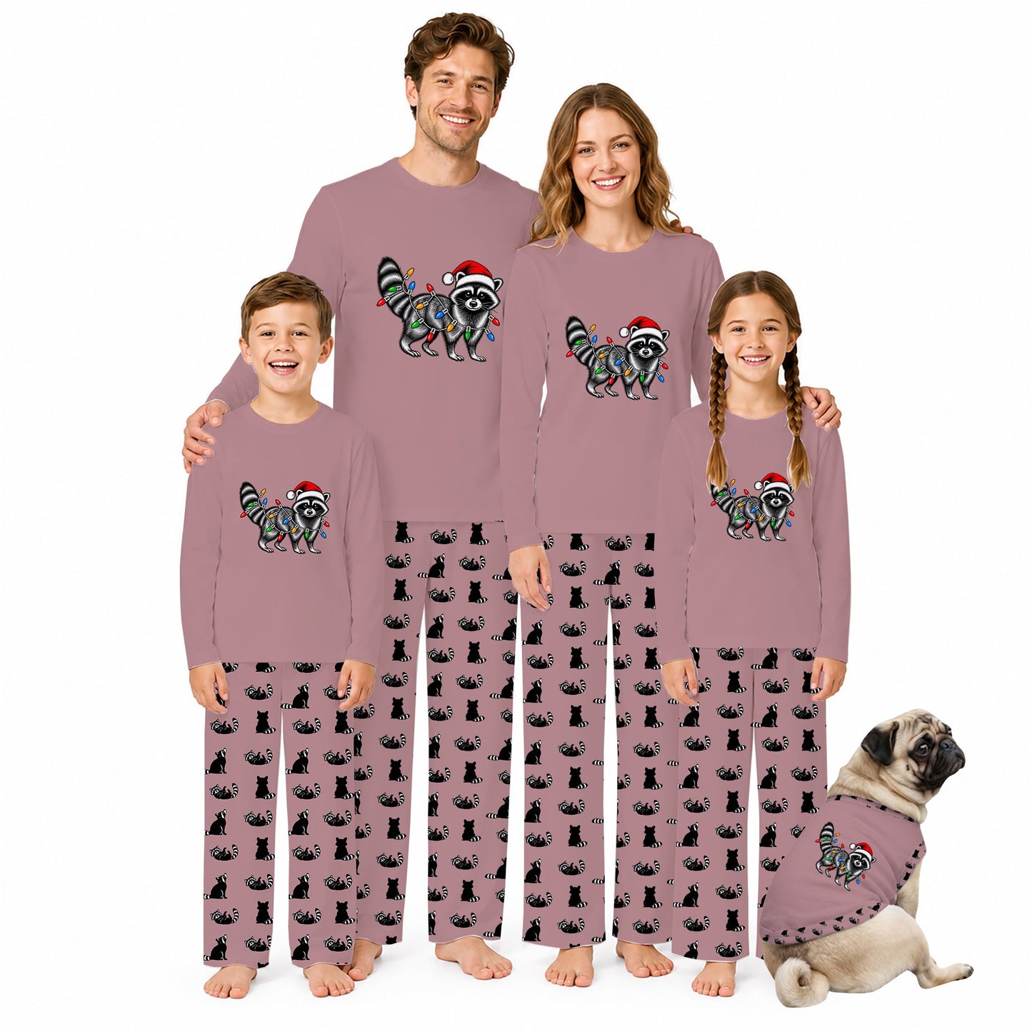 A family of four wearing matching mauve long-sleeve pajamas with a raccoon and Santa hat graphic on the chest, paired with black cat-print pants, standing against a white background with a small cat in a matching pajama vest beside them.