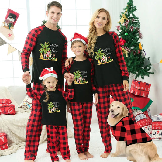 A family of four wearing matching Black and Red plaid Christmas pajamas with a palm tree beach graphic, standing in a decorated living room with a Christmas tree, gifts, and a golden retriever dog wearing a matching shirt.
