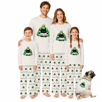 A family of four wearing matching Christmas-themed pajamas stands together on a White background, with a small pug dog sitting at their right. The pajamas are White with a Green and Black Christmas tree graphic on the chest and a repeating Green tree print on the pants.