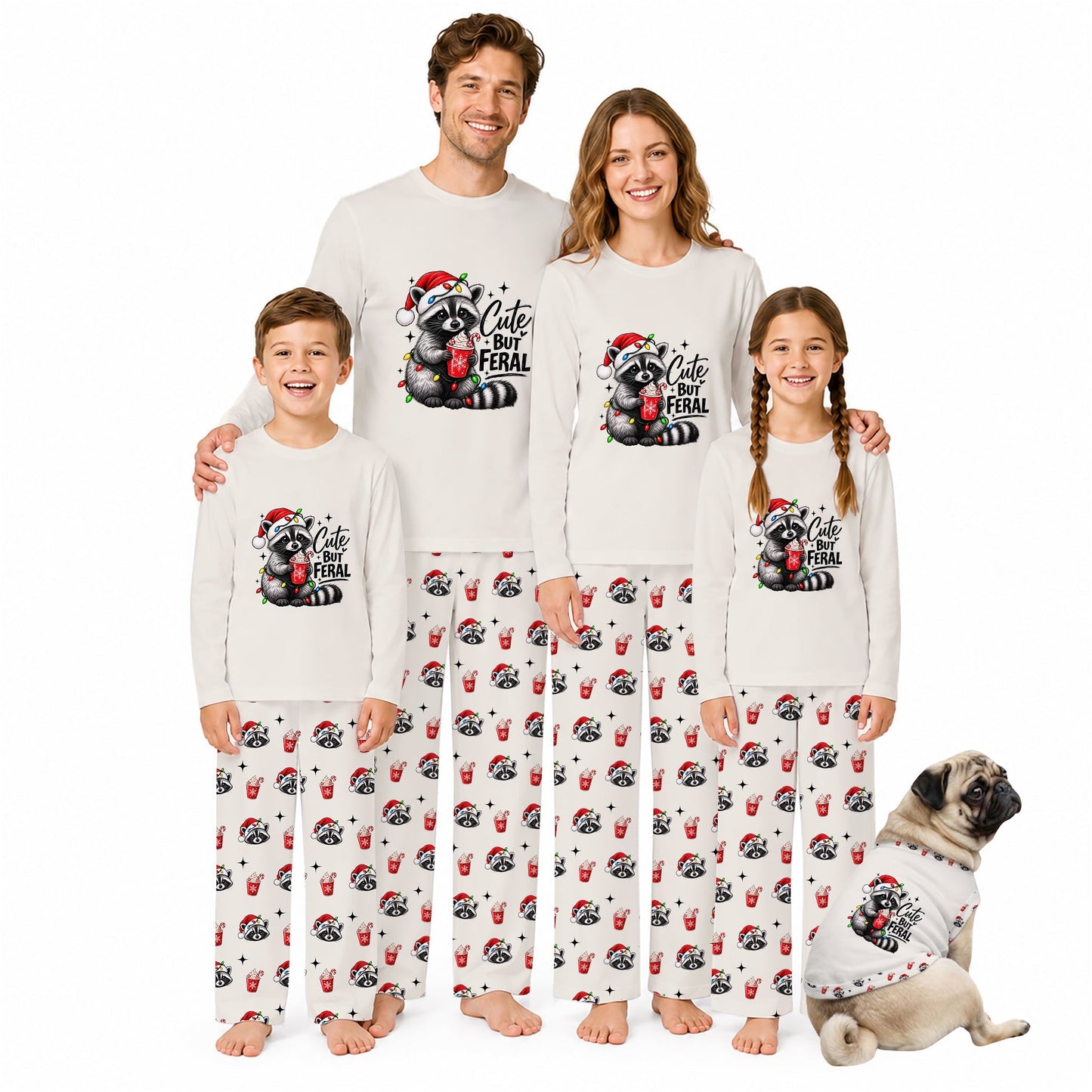 A family of four wearing matching Christmas-themed long-sleeve pajamas and matching pants, standing together on a white background with a small dog wearing a matching pajama shirt at the lower right. The pajamas are off-white with a black and red raccoon graphic and the text 'Cute Feral' on the chest, and the pants have an all-over print of the raccoon graphic.
