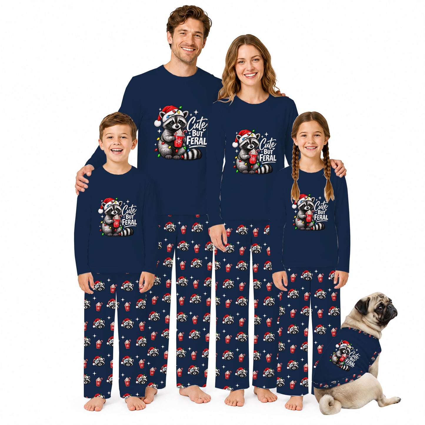 A family of four wearing matching navy blue long-sleeve pajamas with a 'Cute but Feral' raccoon graphic and red-and-white animal print pants, posed with a small matching dog on a white background.