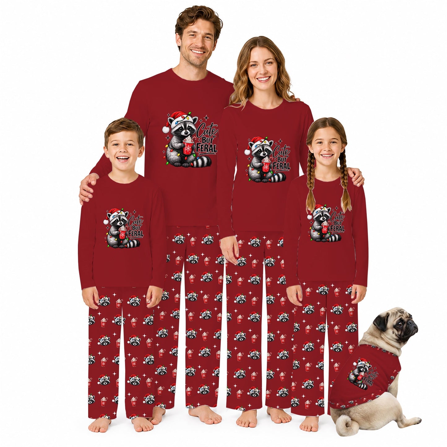 A family of four wearing matching red long-sleeve pajamas with a raccoon graphic and holiday text, standing together on a white background with a small dog in matching pajamas.