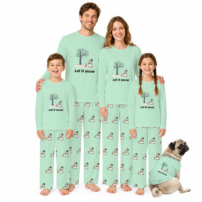 A family pajama set shown on four people and a dog against a plain White background. The matching long-sleeve pajamas are Mint Green with a repeating snowman print and the words 'Let It Snow' on the chest.