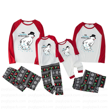 Three matching family Christmas pajama sets shown on a White background, including long-sleeve raglan tops with Red sleeves and a White front with a polar bear graphic and text, plus patterned pants in Black, White, Red, and Green.