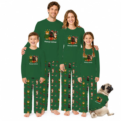 A family of four wearing matching dark Green long-sleeve pajamas with Christmas cat illustrations and text, standing barefoot against a White background, with a pug dog wearing a matching pajama shirt at the lower right.