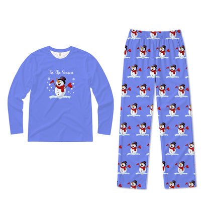 A two-piece pajama set on a White background, featuring a long-sleeve crewneck shirt in periwinkle Blue with a snowman graphic and the text 'In The Snow' on the chest, and matching patterned pants in the same Blue color with an all-over snowman in the snow print.